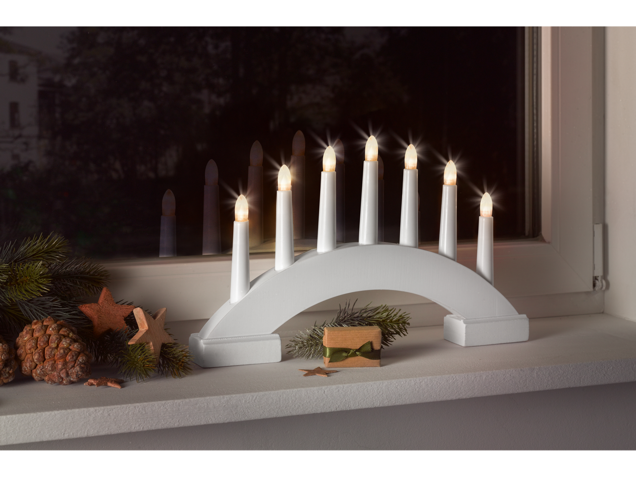 Livarno Home LED žvakidė ant palangės su kalėdinėmis dekoracijomis.