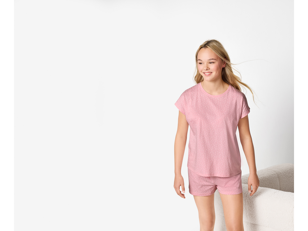 Fată în pijamale roz cu buline albe ESMARA KIDS, zâmbind.