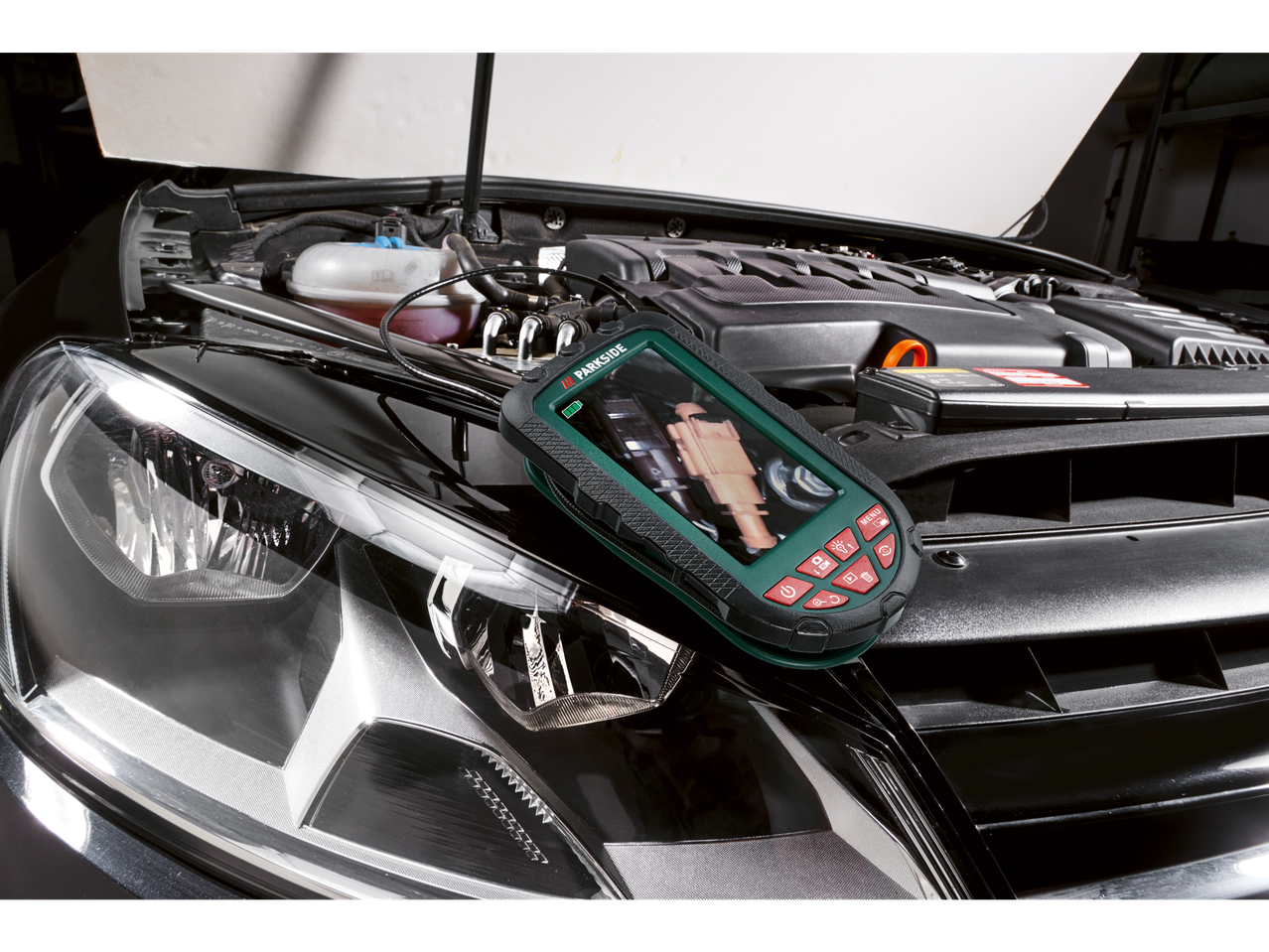 Inšpekcijska kamera PARKSIDE® na odprtem pokrovu motorja avtomobila, ki prikazuje del motorja.