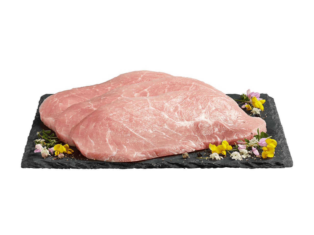 Tranches de viande de porc crue sur une planche en ardoise avec des fleurs et des épices.