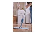 Person mopping a wooden floor with a spray mop in a room with white cabinets.