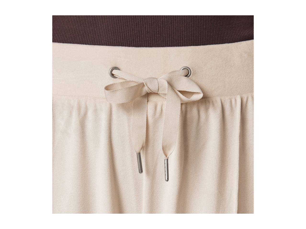 Close-up of beige sweatpants with a brown ribbed waistband and a drawstring tie.
