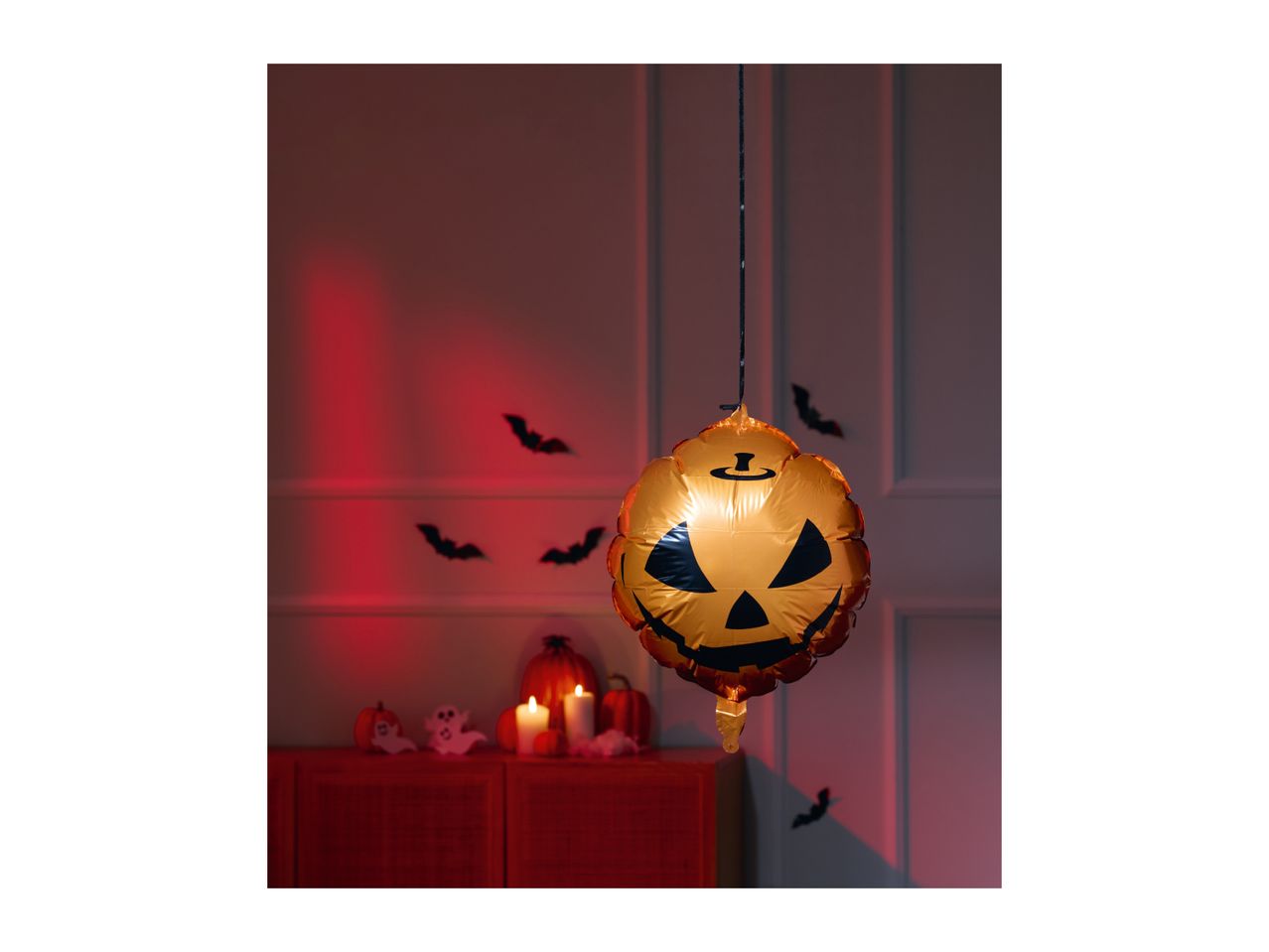 Halloween decorations with a pumpkin balloon, bats, and candles.