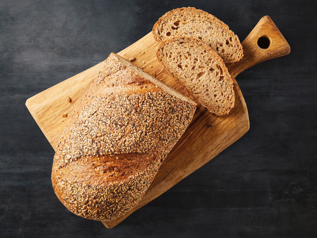 Brot mit Samen, aufgeschnitten auf einem Brett.