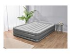 Grey inflatable air mattress in a room with a plant and side table