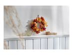 Autumn wreath with pumpkins and leaves, a glass candle holder, and a wooden tray.