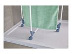 Green towel on a white drying rack with wheels, placed in a shower tray.