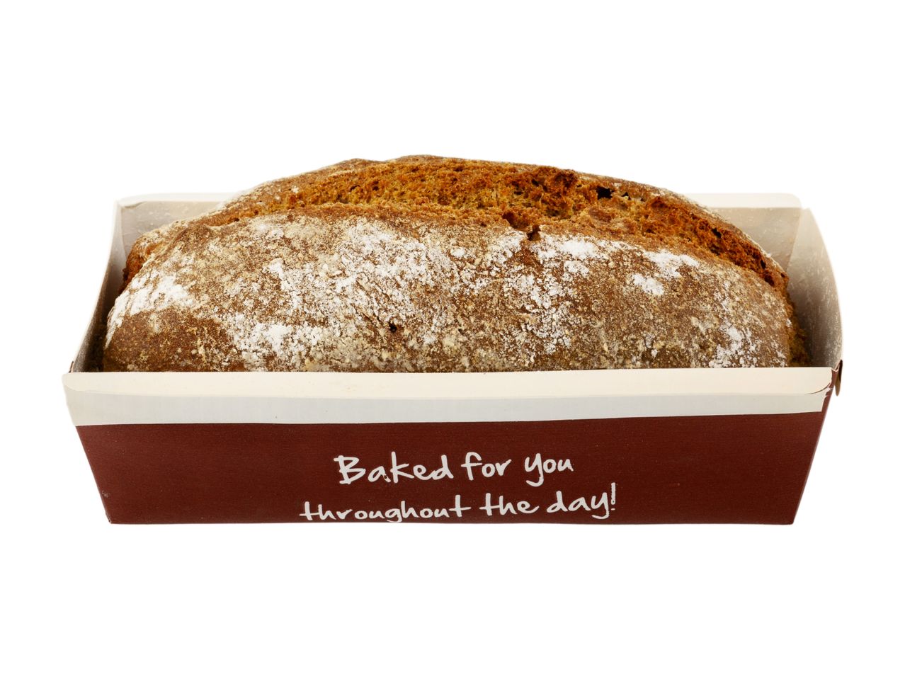 A loaf of sourdough bread in a brown paper baking tin.