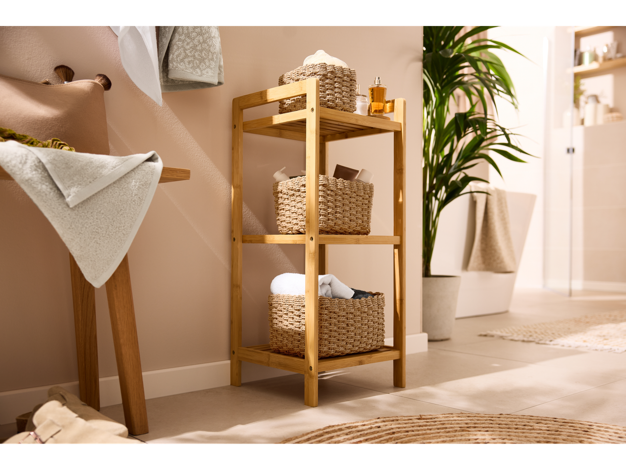 Kupaonica s bambusovom policom, košarama, ručnicima i biljkama, s W5 proizvodima.