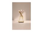 Gold-colored rotating mirror with a rectangular base on a light beige surface.
