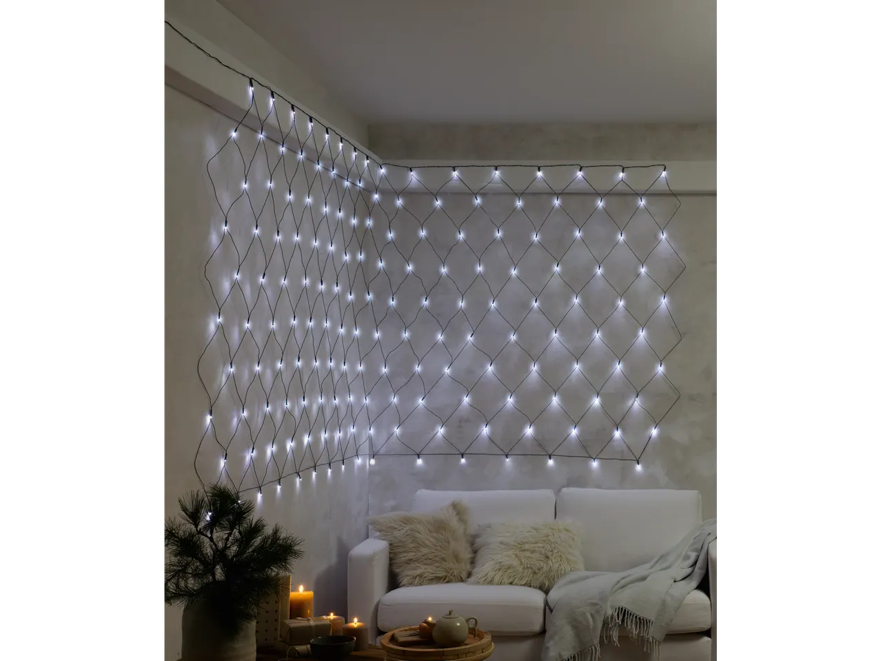 Livarno home LED-valgusvõrk valgustab elutoa seina diivani kohal.