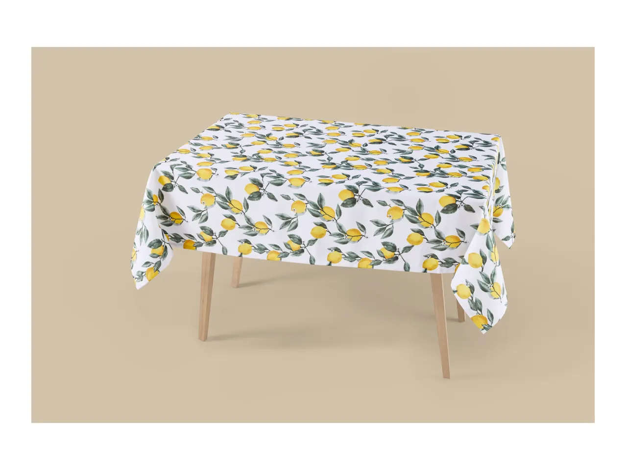 White tablecloth with a vibrant lemon and leaf pattern on a wooden table.