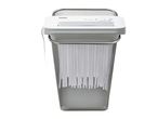 TRONIC paper shredder with a mesh wastebasket, shredding paper strips.