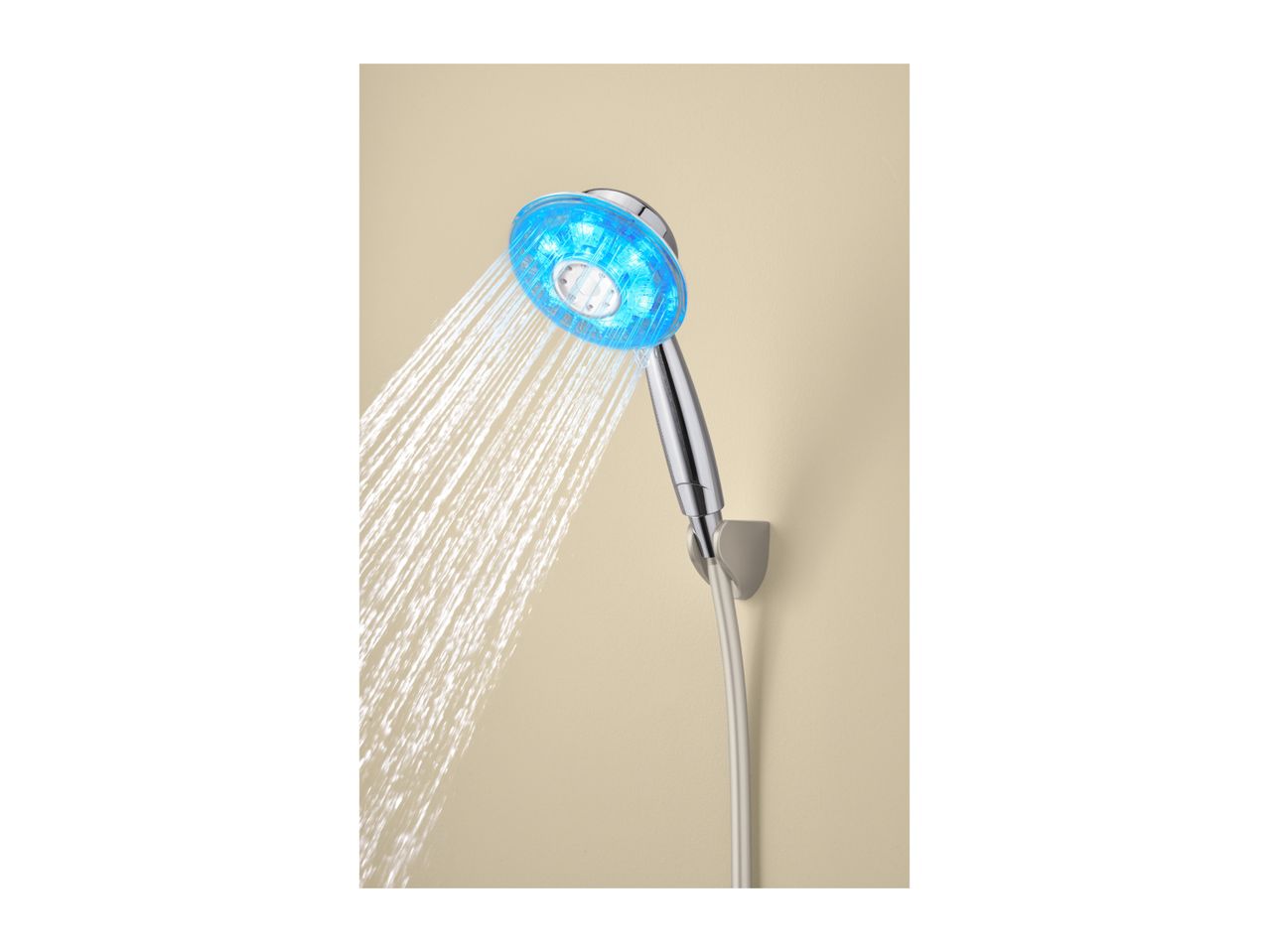 A chrome shower head with blue LED lights spraying water against a beige wall.