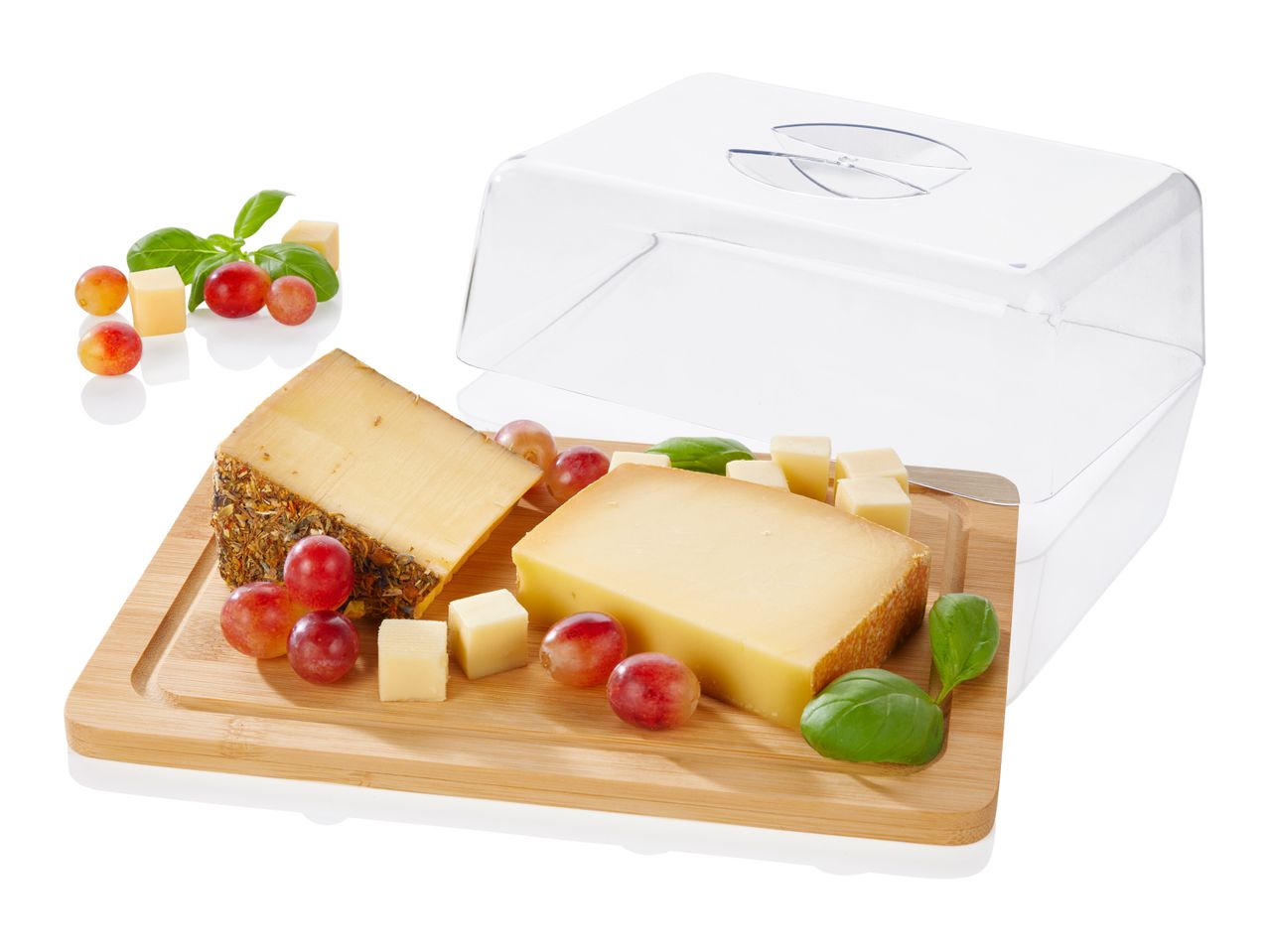 A clear plastic cheese dome sits atop a wooden cheese board with cheese and grapes.