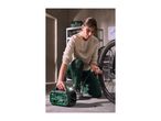 Person inflating a bicycle tire with a portable air compressor in a garage.