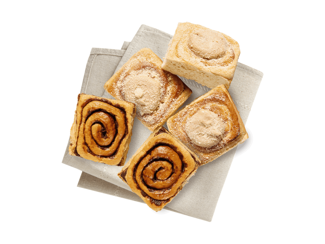 Fünf Zimtschnecken und eine Vanilleschnecke auf einem Leinentuch.