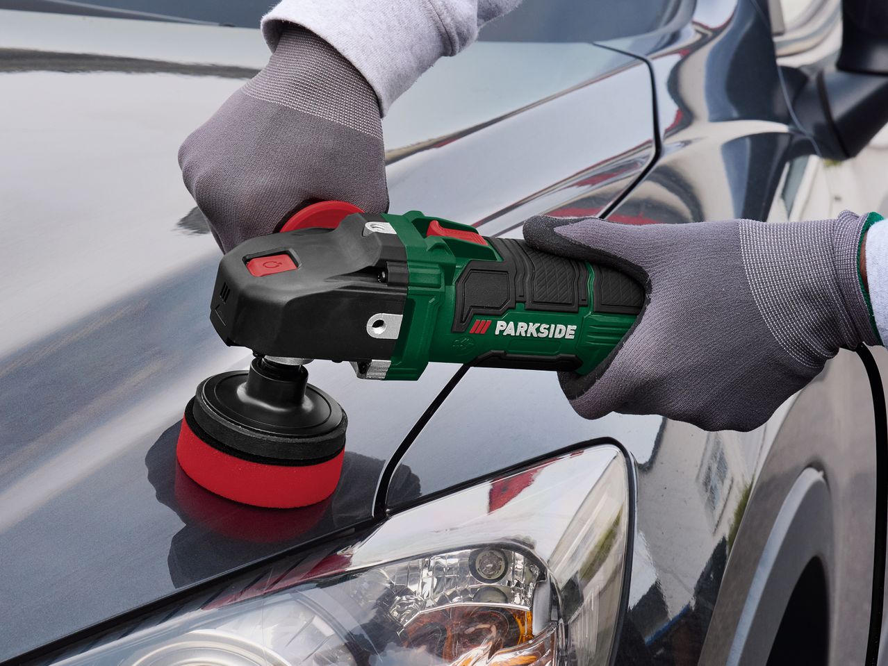 Žmogus poliruoja automobilio kėbulą Einhell poliravimo mašina.