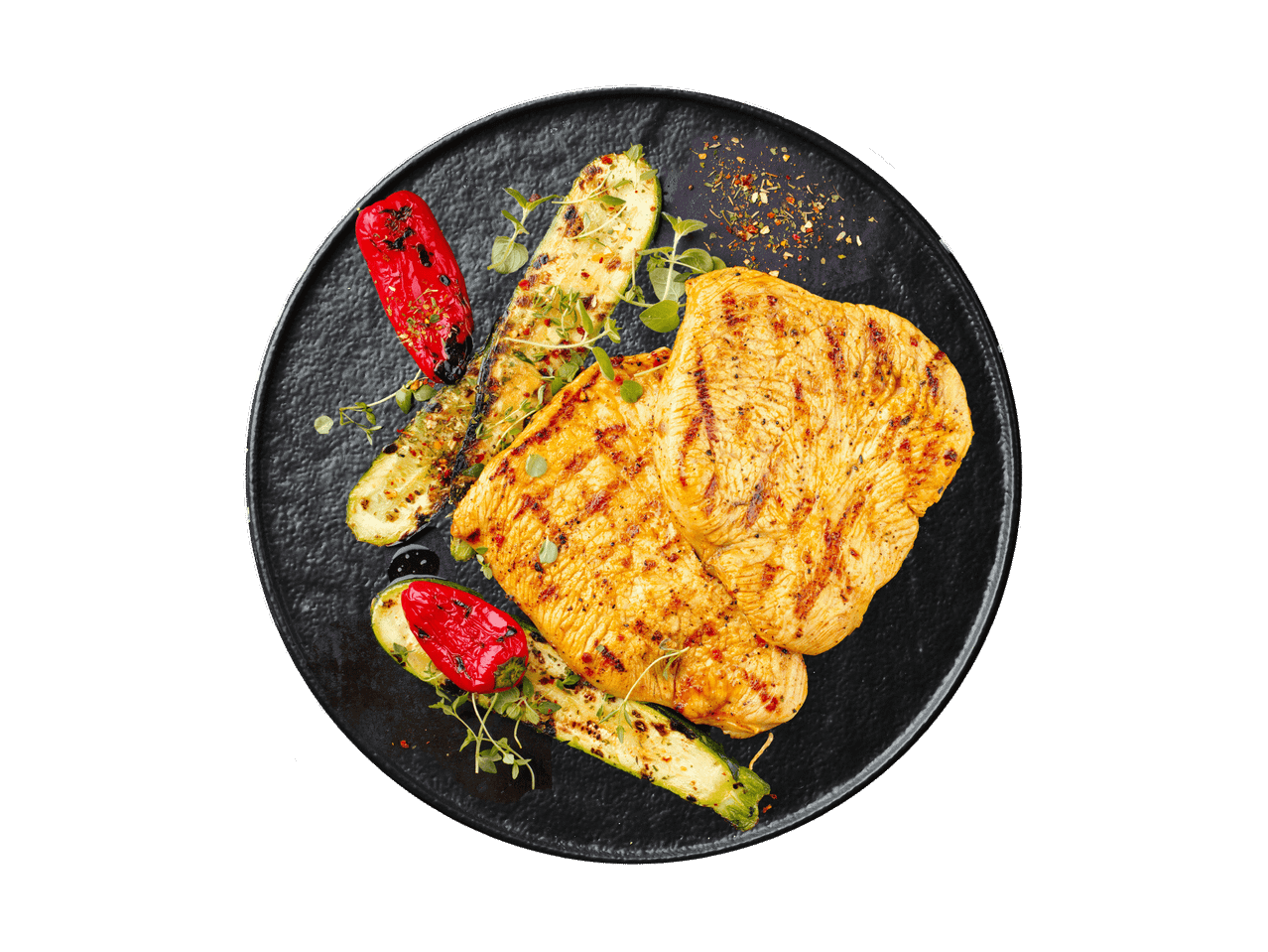 Gegrilltes Hähnchenbrustfilet mit Zucchini und Paprika auf einem schwarzen Teller.