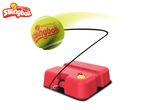 A tennis trainer with a red base and a tennis ball attached by a black cord.