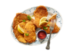 Gebakken schnitzels, citroen en ketchup.