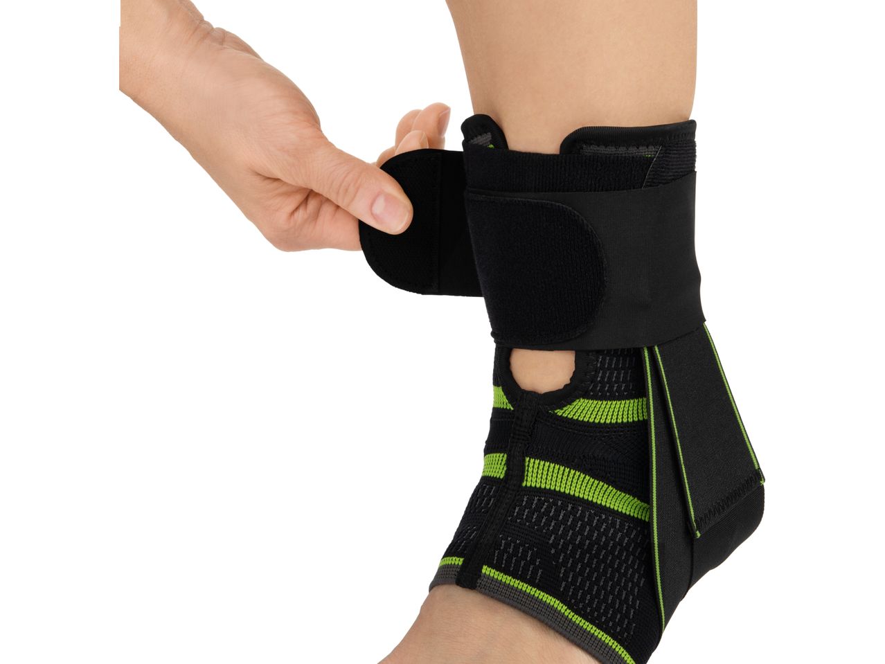 A person adjusting a black and green ankle brace with a hook-and-loop fastener.