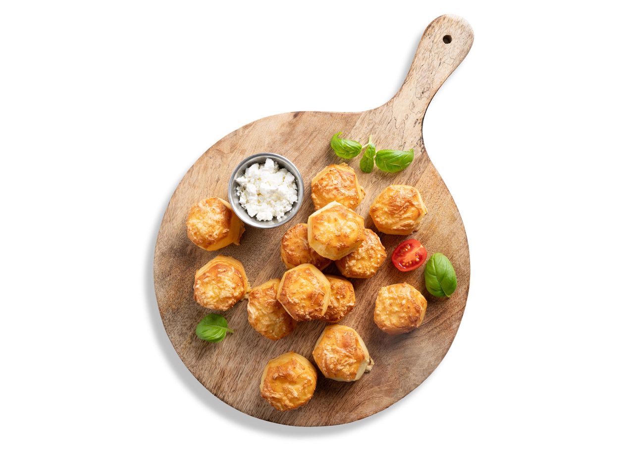 Sajtos pogácsák, feta sajt és bazsalikomlevelek egy fa vágódeszkán.