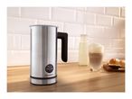 Stainless steel milk frother on a wooden counter with a latte, milk bottle, and pastries.
