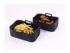 Two black silicone air fryer baskets, one with fries and one with chicken wings.