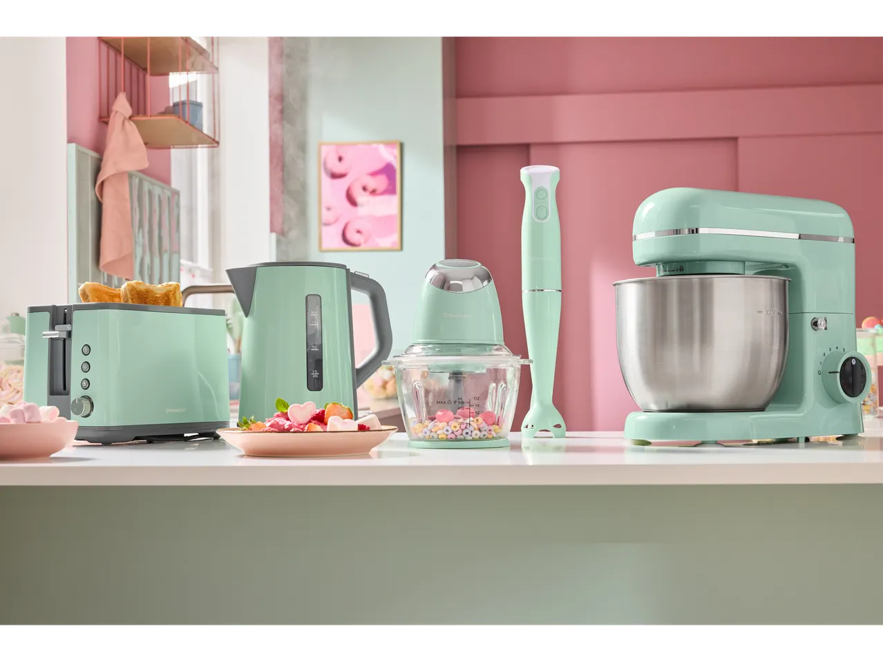 SilverCrest pastel-green kitchen appliances: stand mixer, kettle, toaster, hand blender, and food chopper.