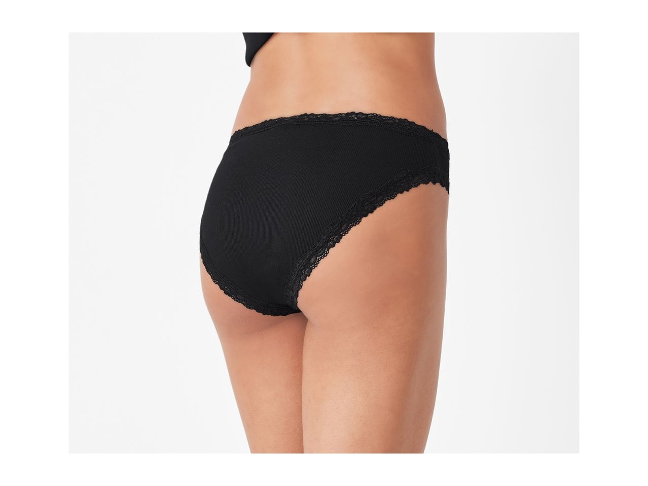 Woman wearing black ribbed lace trim briefs, side view.