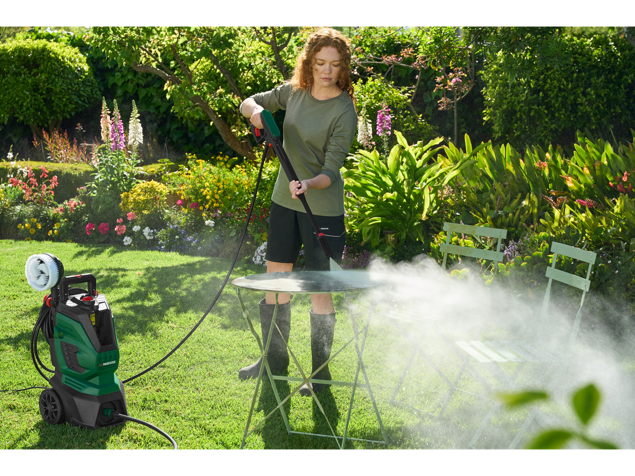 Naine puhastab aias Parkside® survepesuriga aialauda.