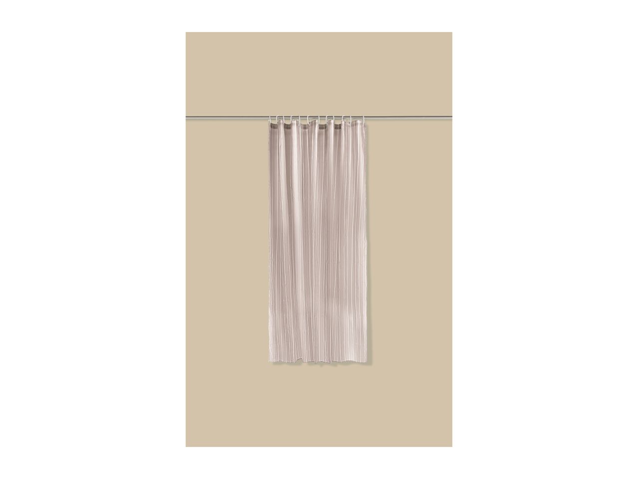 A single, light-colored shower curtain hanging on a silver rod with white hooks.
