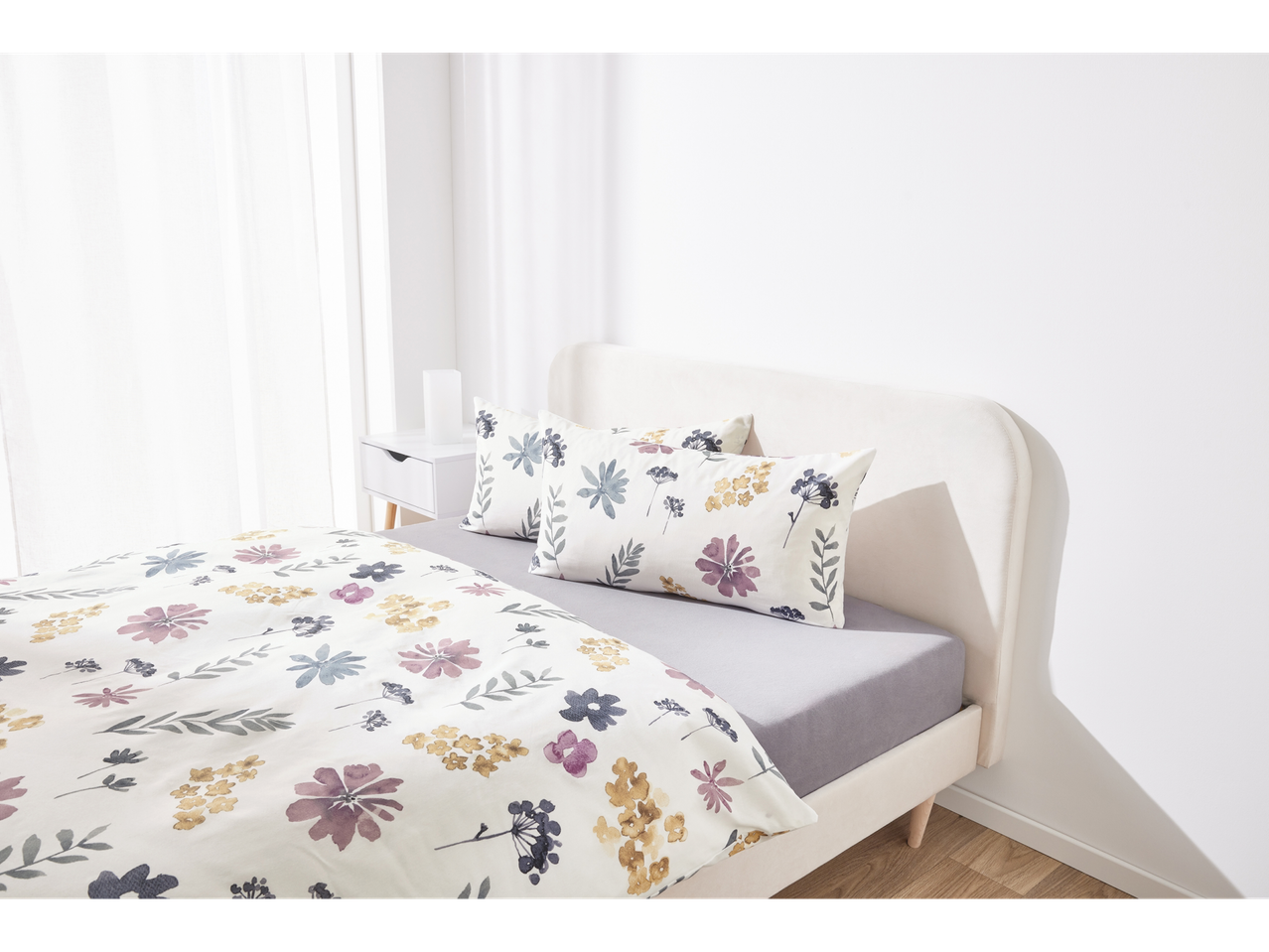 Set di biancheria da letto floreale: copripiumino e cuscini con fiori in stile acquerello.