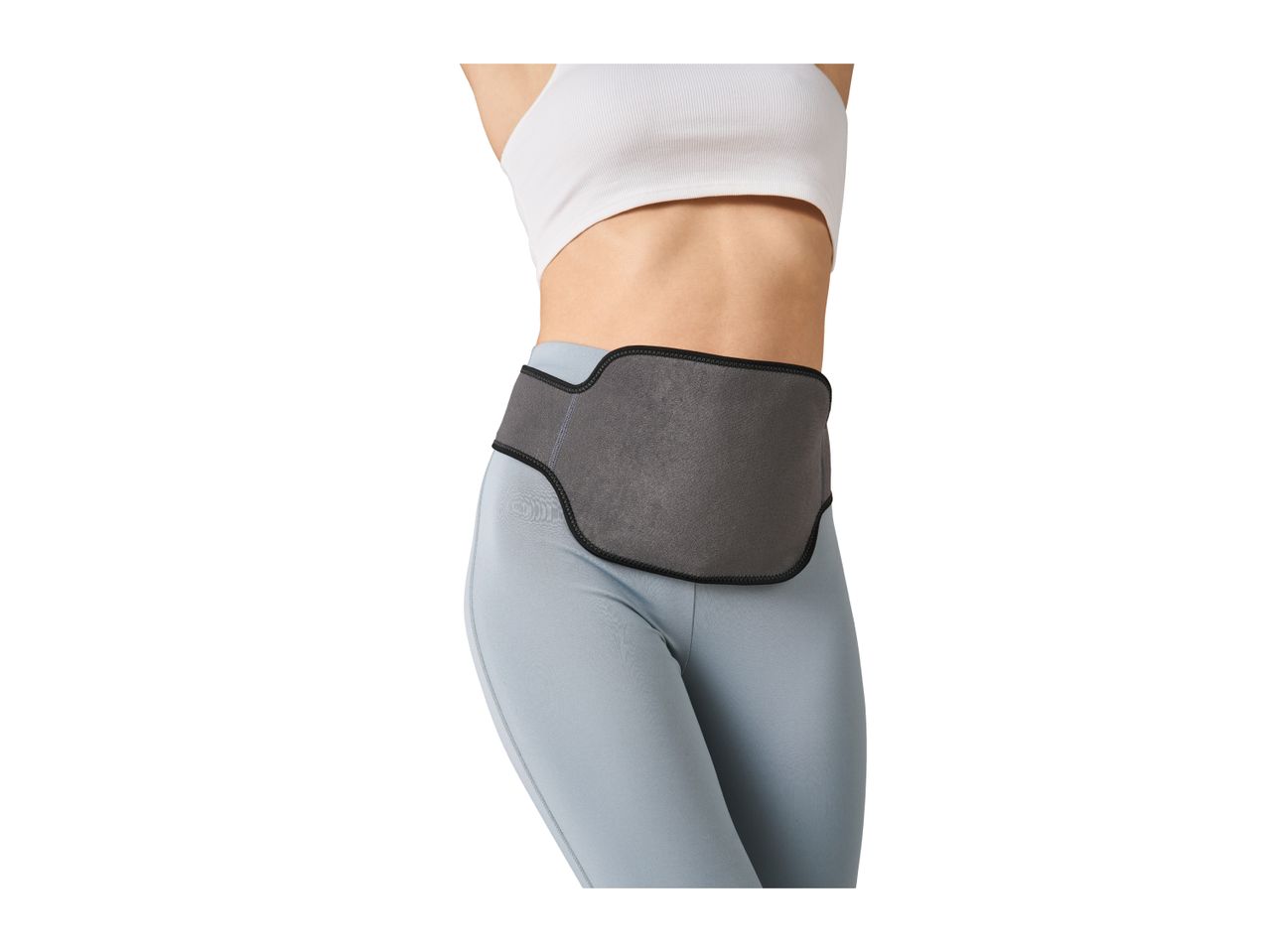 Woman wearing a grey waist trimmer belt over light blue leggings and a white sports bra.