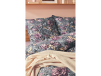 Floral bedding with pillows and a light throw blanket.