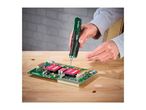 A person soldering a circuit board with a cordless soldering iron.