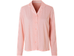 A peach-colored women's long-sleeve pajama top with a subtle white pattern and button closure.
