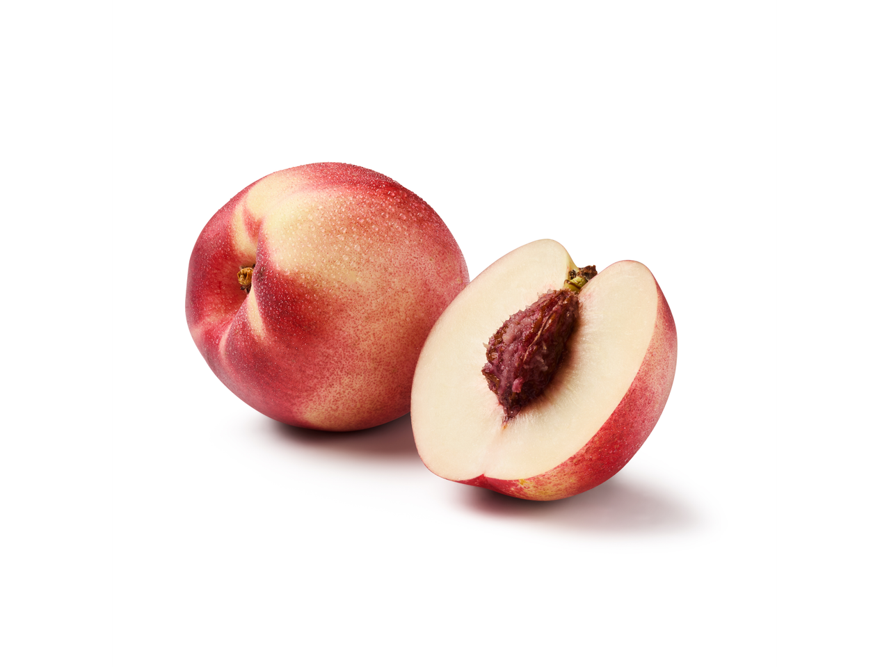 Vesels nektārīns un pusnektārīns, sagriezts uz pusēm, uz balta fona.