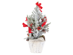Snow-covered Christmas tree in a white basket with red decorations.
