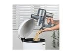 Handheld vacuum cleaner emptying debris into a white bin with a lid.