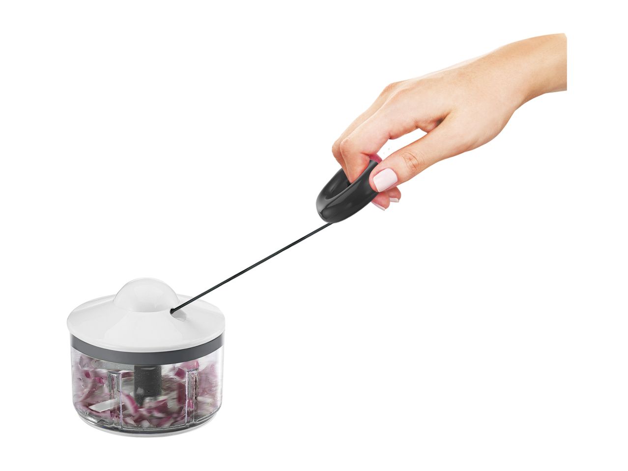 Hand pulling the cord of a manual food chopper filled with chopped red onions