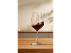 Un pahar de vin roșu pe o masă din lemn.