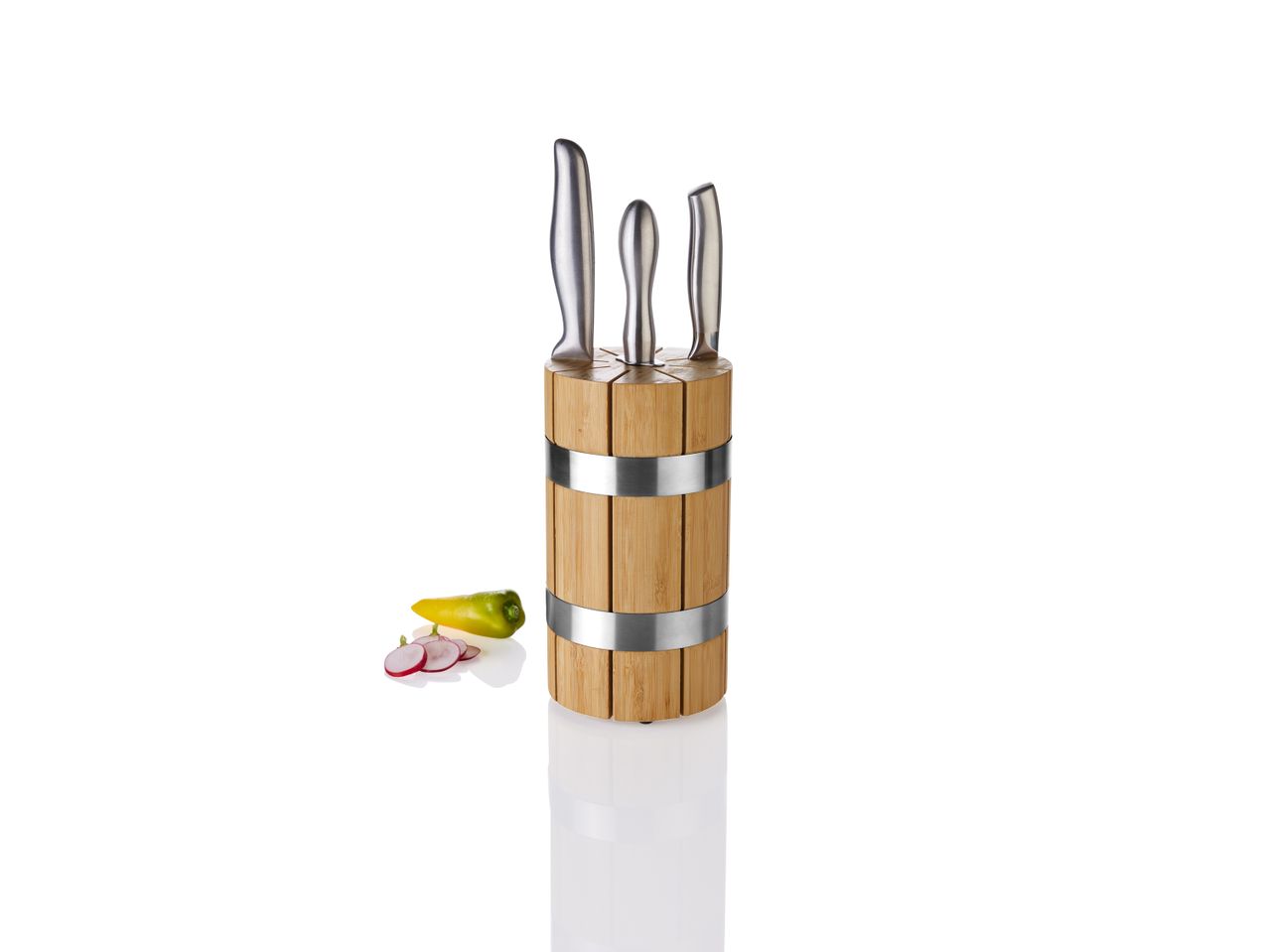 Knife block with three knives, a yellow pepper, and sliced radishes on a white background.