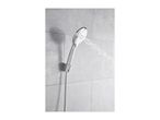 Chrome shower head spraying water, mounted on a grey tiled wall.