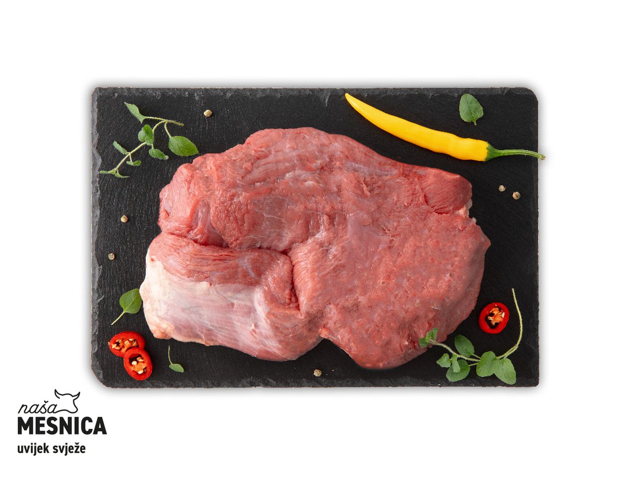 Sirovo meso na crnoj podlozi, začini i paprika.