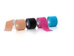 Four rolls of kinesiology tape in beige, black, pink, and blue, with reflections.
