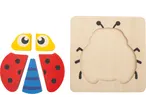 Puzzle in legno LUPILU® con coccinella in pezzi separati e una tavola di legno con sagoma di coccinella.