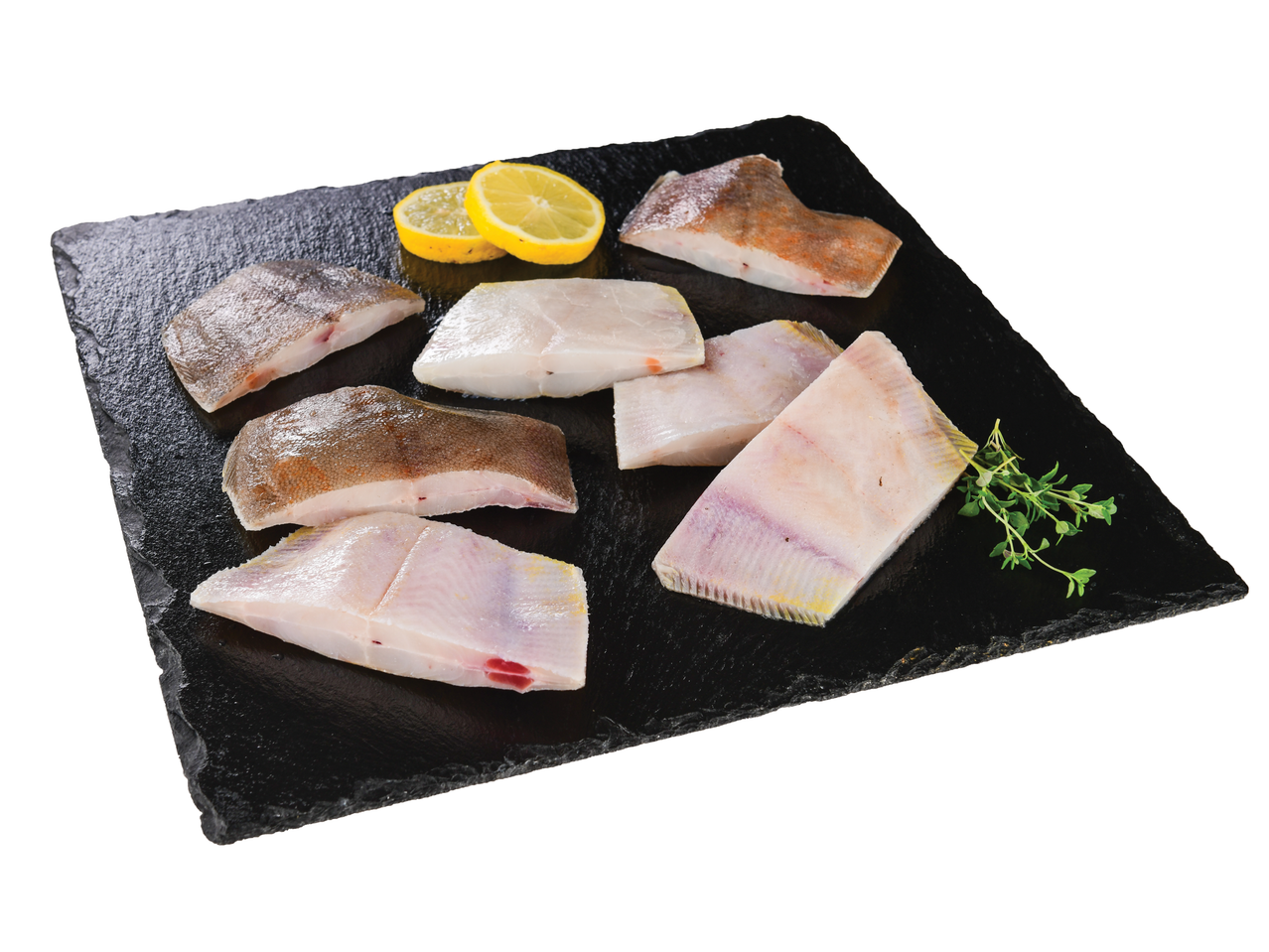 Filetes frescos de linguado em pedra preta, decorados com fatias de limão e tomilho.
