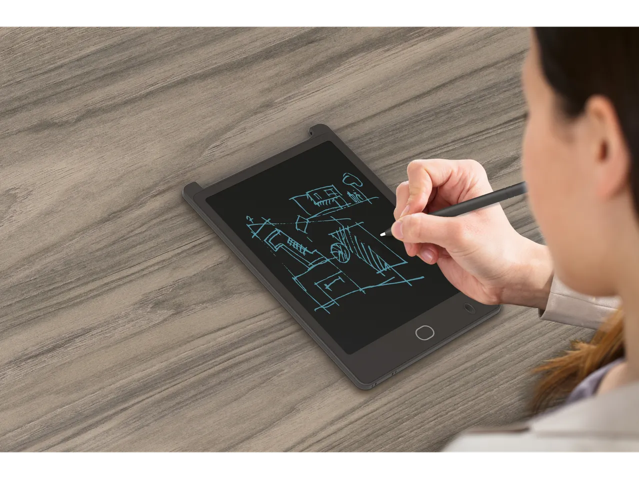 A woman sketches a building design on a black LCD writing tablet using a stylus.